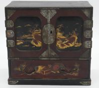 A Japanese Meji period lacquered and gilded miniature cabinet with engraved white metal fittings.