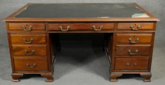 A mid 20th century Georgian style mahogany desk with brass swan neck handles on ogee bracket feet.