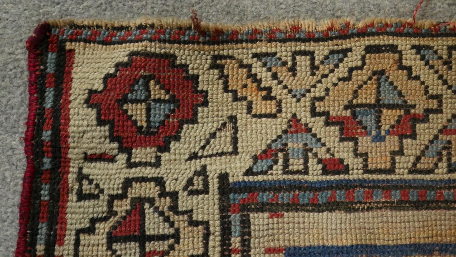 A Kazak rug with repeating star medallions on a sapphire ground within stylised multiple borders. - Image 2 of 3