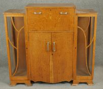 A mid century light oak Art deco style drinks cabinet with mirrored and fitted pull out drink's