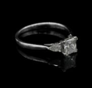 An 18 carat white gold and diamond three stone ring. Set to centre with a square princess cut