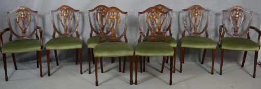 A set of eight Georgian style mahogany dining chairs with carved shield backs on tapering square