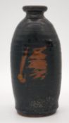 A Oriental black glazed terracotta sake bottle/vase with abstract design. H.24cm
