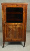 A late 19th century rosewood music cabinet with carved and glazed panel door enclosing sheet music