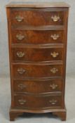 A Georgian style burr walnut and mahogany crossbanded tall chest of drawers of serpentine outline.