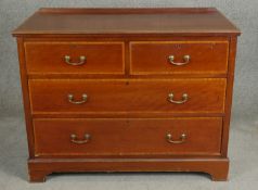 An Edwardian mahogany and satinwood strung chest of drawers with brass swing handles on bracket