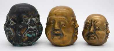 Three Tibetan brass four faces buddha heads, graduating in size. Character mark to base. H.12cm