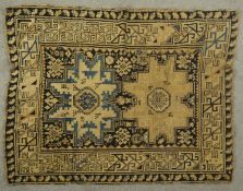 A Kazak rug with central star medallions on a midnight ground. L.120 W.97cm