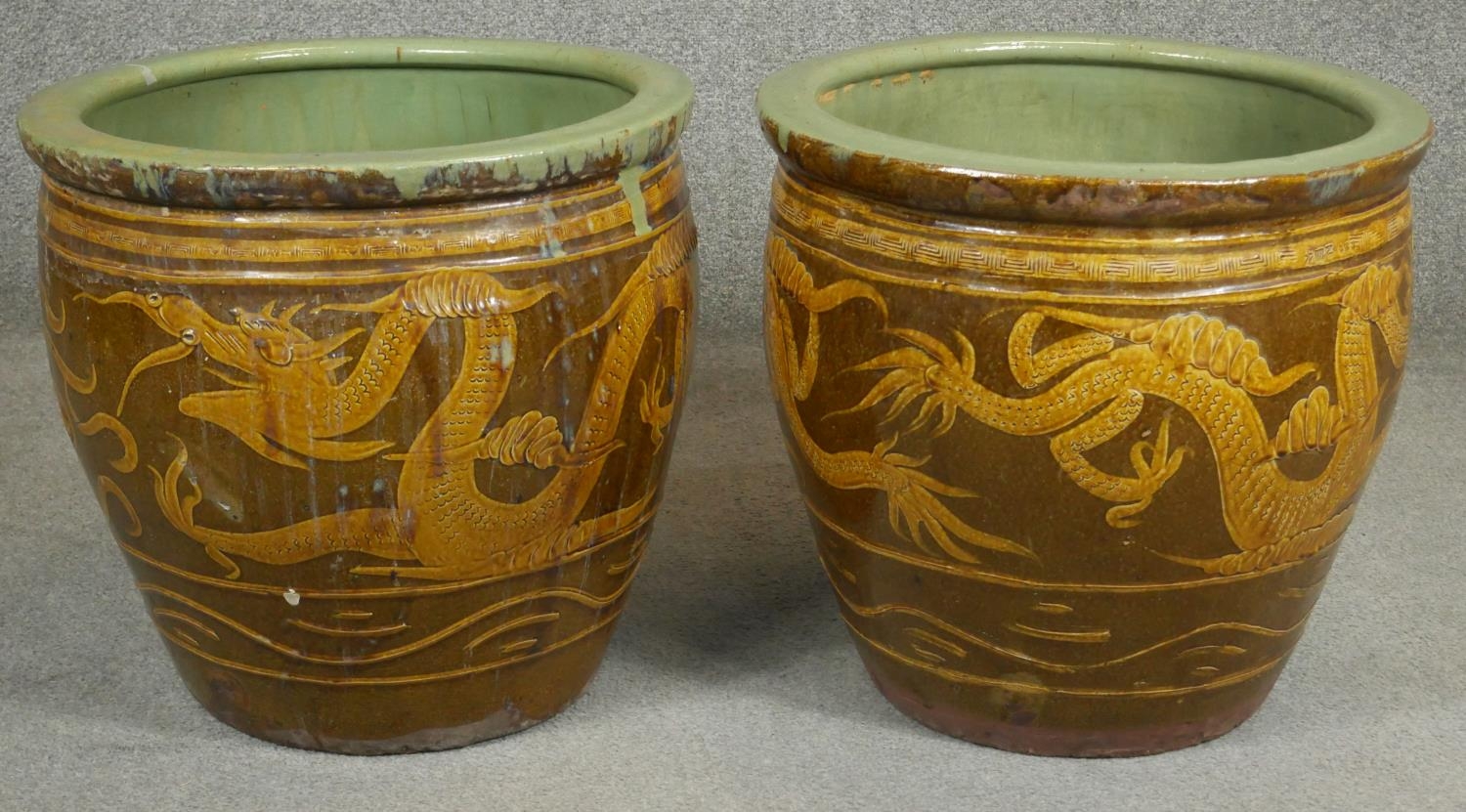 A pair of Chinese earthenware dragon glazed garden planters. H.47cm