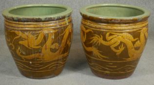 A pair of Chinese earthenware dragon glazed garden planters. H.47cm