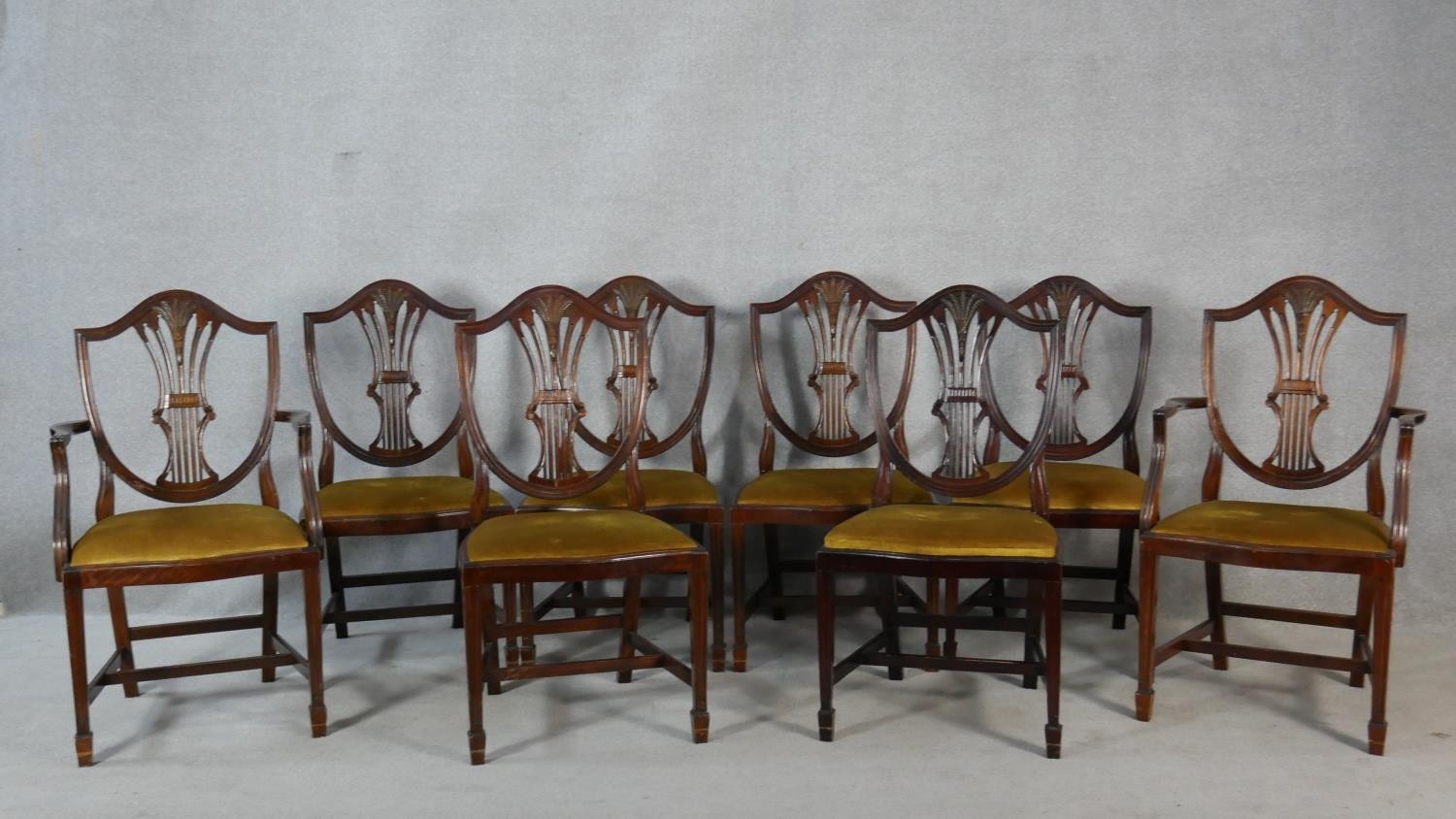 A set of eight mahogany Hepplewhite style dining chairs with pierced wheatsheaf backs above drop