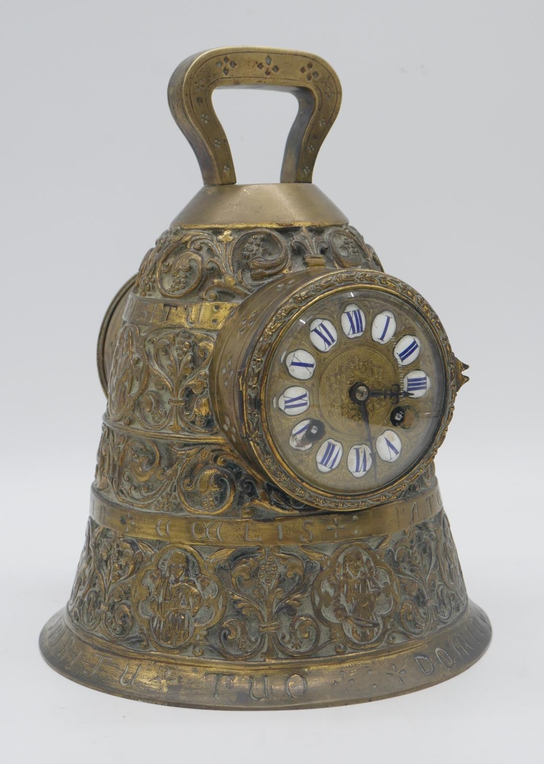 A 19th century French brass mantel clock modelled as a bell, the dial with enamel Roman numerals,