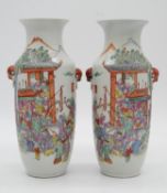 A pair of late 19th century Chinese porcelain vases, hand painted with a temple festival scene, with