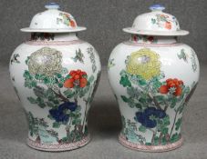 A pair of 20th century hand painted porcelain temple jars with lids. Decorated with birds and