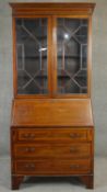 An Edwardian mahogany and satinwood crossbanded two section bureau bookcase with fitted interior