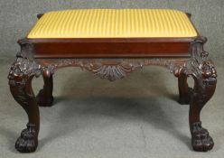 A mid Georgian style mahogany stool with drop in seat above mask carved cabriole supports on hairy