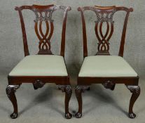 A pair of mid Georgian style mahogany dining chairs with pierced splats and drop in seats on shell