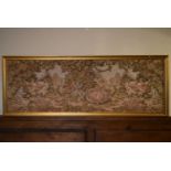 A large gilt framed Aubusson style wall hanging of a garden dance scene. H.75 W.204cm