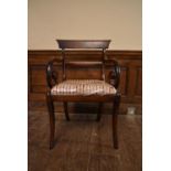 A Regency mahogany bar back armchair with scroll arms and drop in upholstered seat on sabre