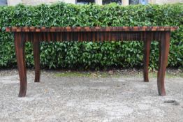 A contemporary zebra wood extending draw leaf dining table raised on square tapering shaped