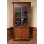 A Georgian mahogany and satinwood inlaid corner cupboard with dentil moulded cornice above