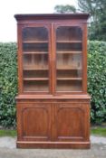 A mid 19th century mahogany library bookcase, the upper section with arched glazed doors enclosing