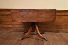 A Regency mahogany drop flap Pembroke table on quadruped swept supports terminating in brass lion'