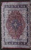 A Persian Keshan carpet with floral central medallion on burgundy ground within foliate spandrels