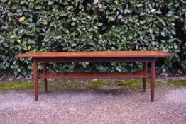 A vintage teak coffee table fitted with undertier on shaped tapering supports. H.16 W.113 D.38cm