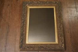 A late 19th century gilt wood and gesso wall mirror with scrolling Art Nouveau style decoration. H.