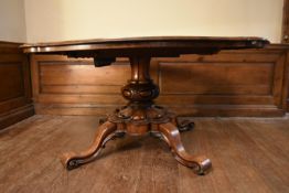A mid Victorian tilt top rosewood dining table with shaped top on well carved quadruped pedestal