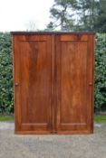 A 19th century flame mahogany two section wardrobe with panel doors enclosing full height hanging