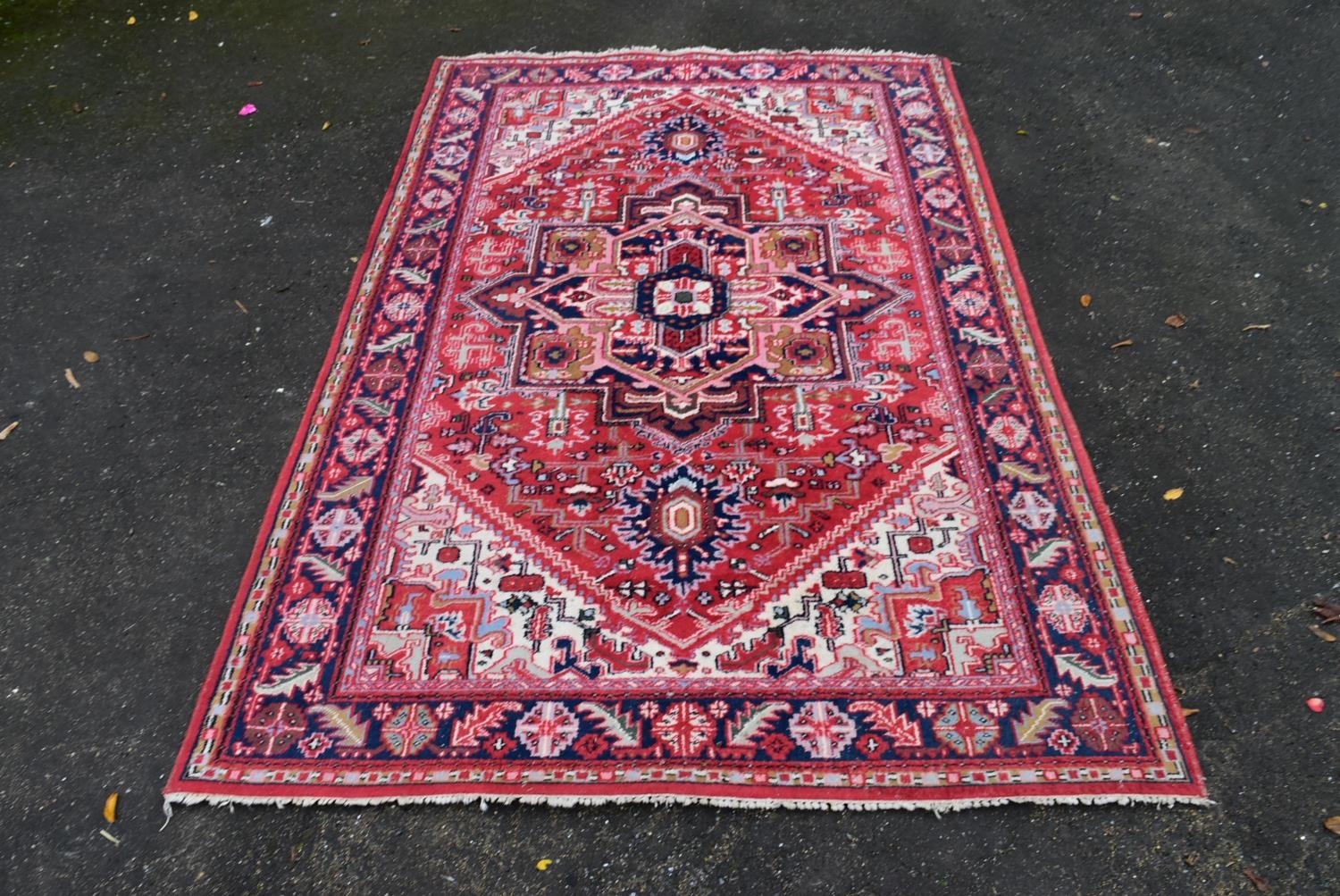 A Persian Heriz carpet with central star medallion on a burgundy ground within a foliate multiple - Image 2 of 4