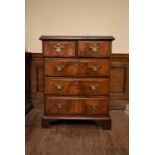 An 18th century figured walnut, crossbanded and featherbanded chest of drawers on shaped bracket
