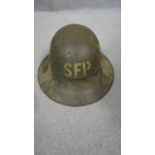 A WW2 Zuckerman painted metal helmet with canvas lining. Numbered and stamped.