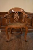 A Victorian oak captains style desk chair with caned seat on cabriole supports. H.90 W.64 D.50cm