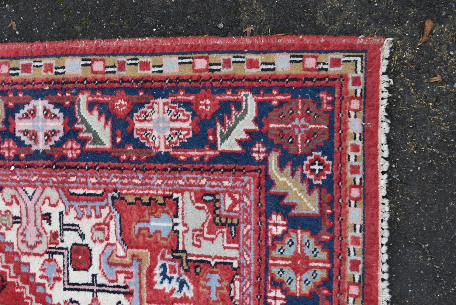 A Persian Heriz carpet with central star medallion on a burgundy ground within a foliate multiple - Image 4 of 4