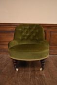 A Victorian tub shaped nursing chair in buttoned upholstery on turned tapering supports resting on