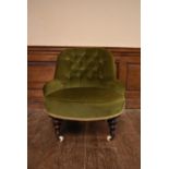 A Victorian tub shaped nursing chair in buttoned upholstery on turned tapering supports resting on