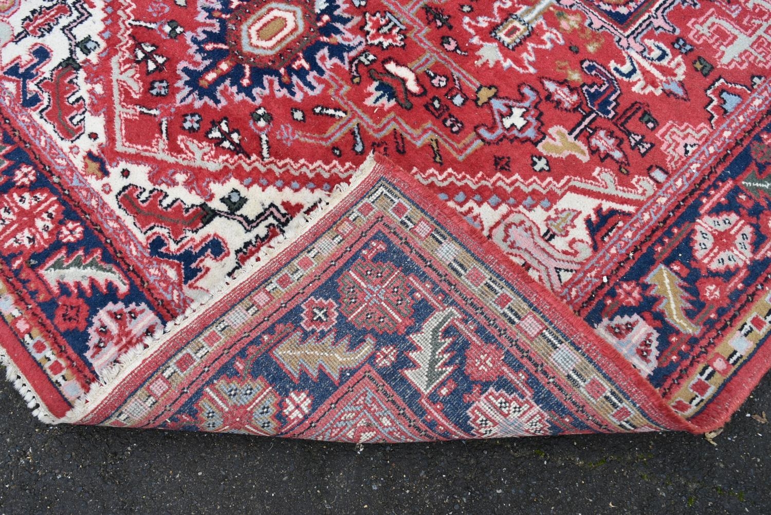 A Persian Heriz carpet with central star medallion on a burgundy ground within a foliate multiple - Image 3 of 4