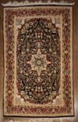 An Indian Agra silk rug with central floral medallion on midnight ground within naturalistic foliate