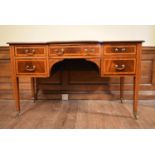 An Edwardian mahogany and satinwood inlaid writing desk with inset gilt tooled leather top raised on