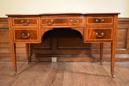 An Edwardian mahogany and satinwood inlaid writing desk with inset gilt tooled leather top raised on