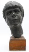 A hollow bronze female sculpted head on wooden stand. H.45cm