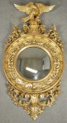 An early 19th century giltwood wall mirror with ho ho bird surmount with suspended ball from its