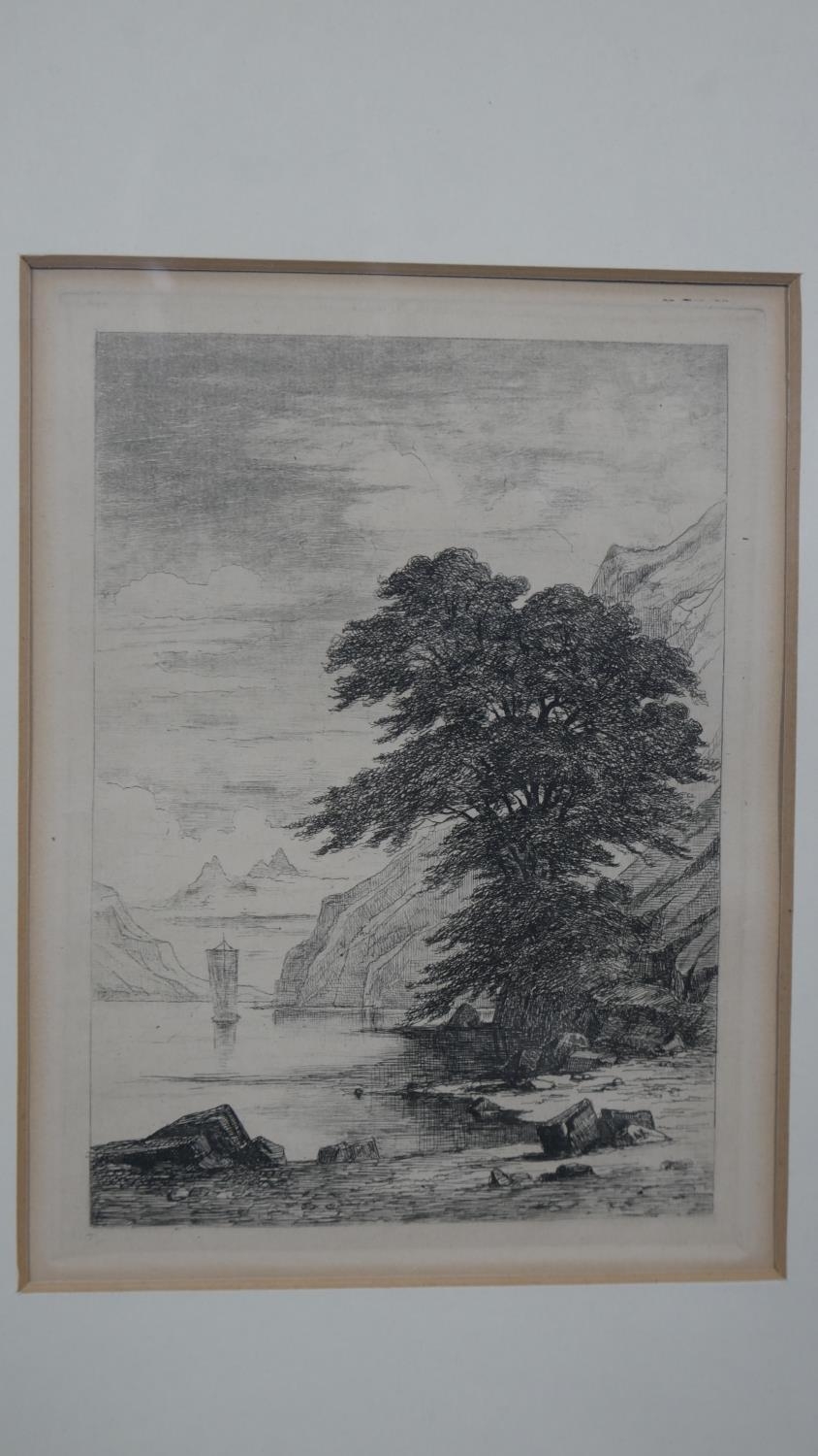 A 19th century framed and glazed etching of a mountain lake with a boat in the background. Titled