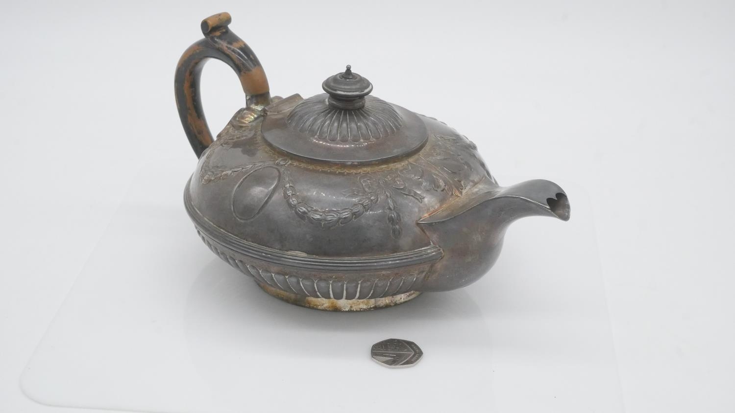 A sterling silver Georgian teapot with dragooned detailing and repousse swag and bow motifs. - Image 7 of 7
