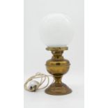 A vintage brass oil lamp with milk glass globe shade converted to electricity. H.38cm