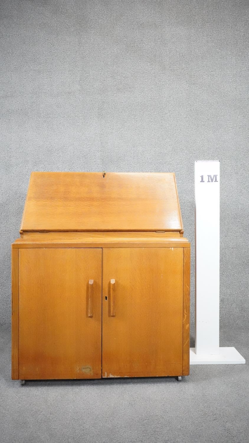 A vintage light oak bureau with fitted interior above panel doors enclosing slides. H.95cm - Image 5 of 5