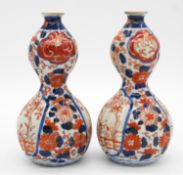 A pair of Japanese Imari double gourd porcelain vases, decorated with flowers and a bridge over a